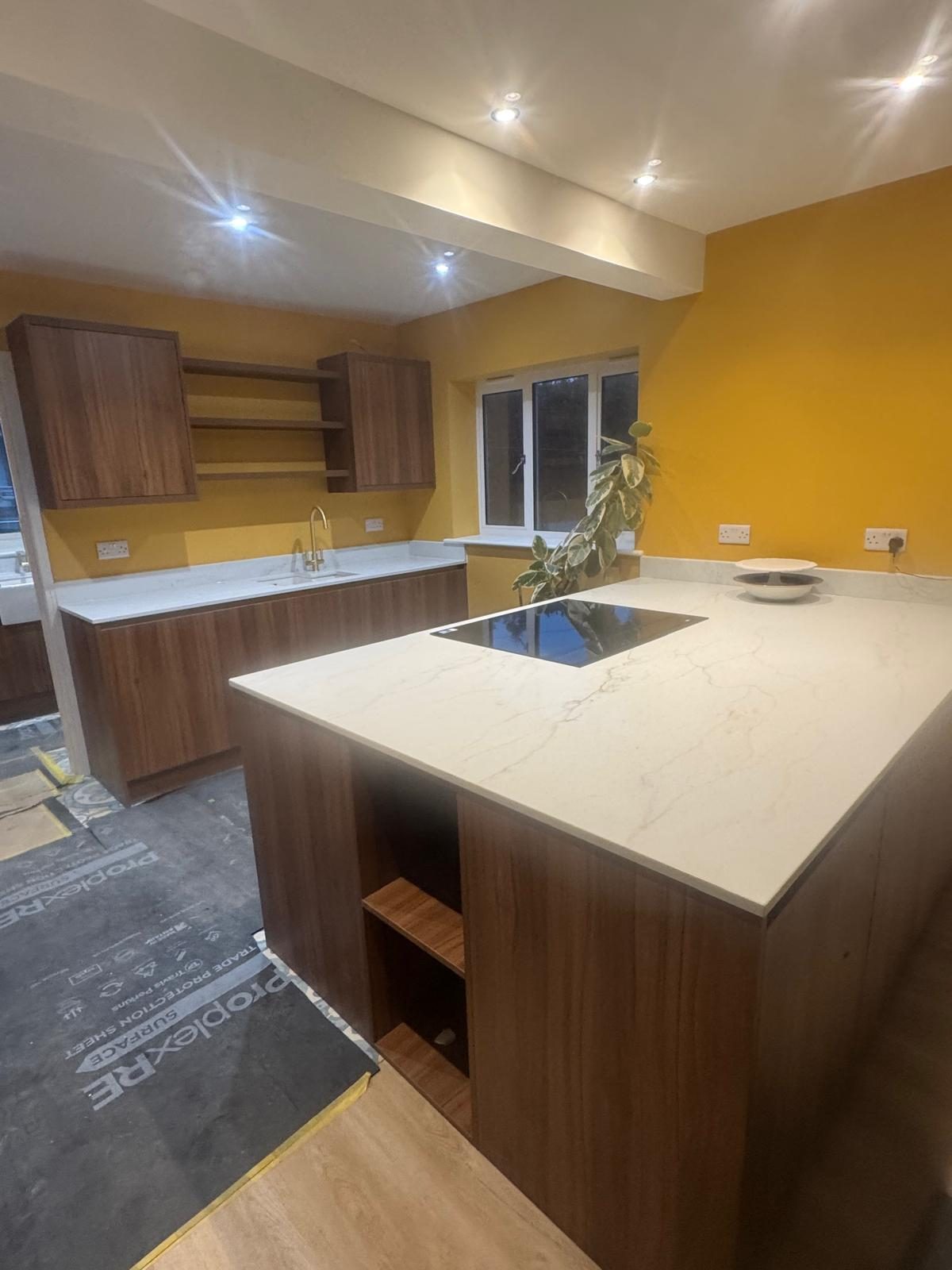 Walnut kitchen island with white quartz worktop and induction hob