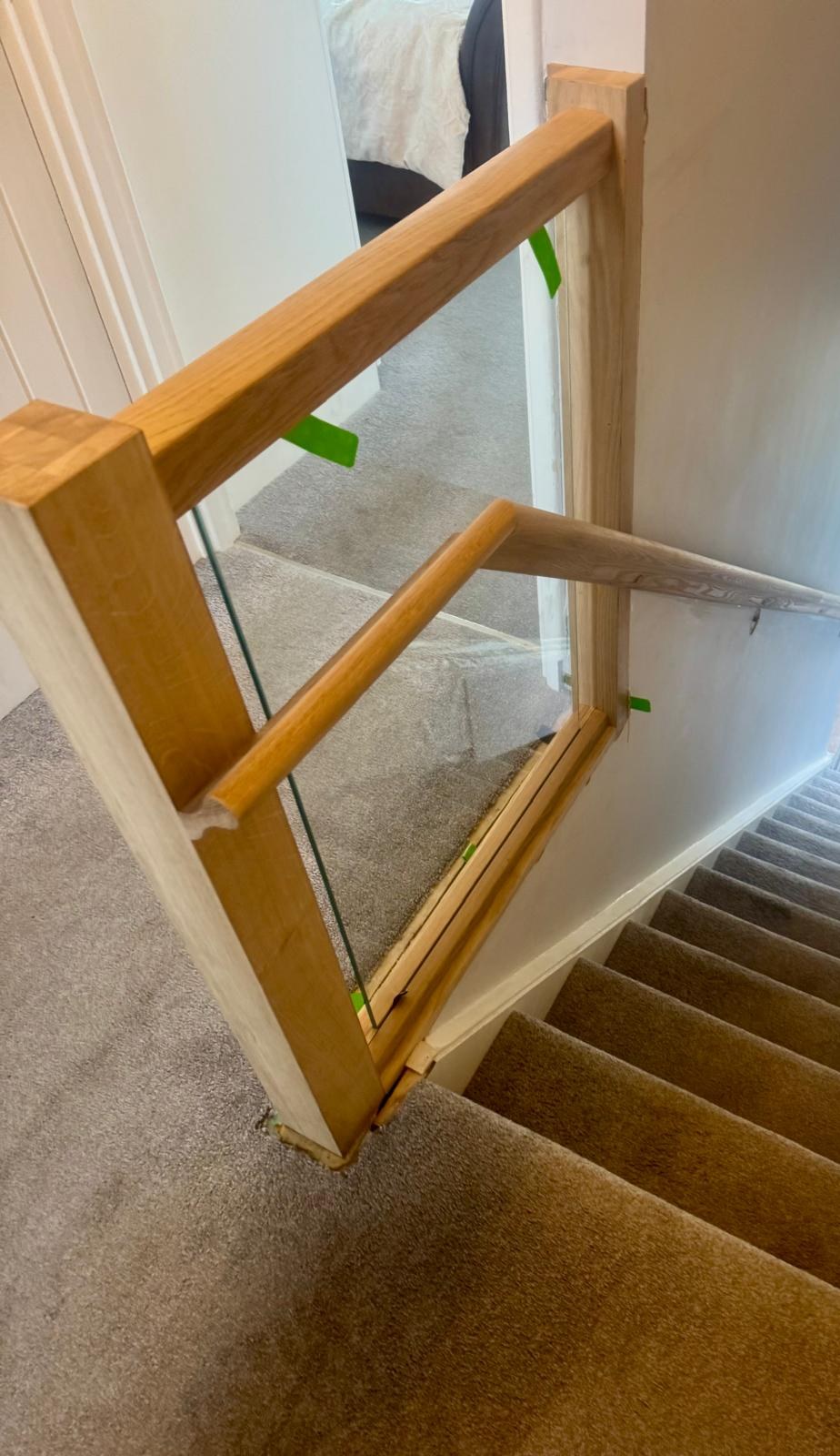 Oak and glass landing balustrade with oak handrail fitted above a staircase in West Sussex