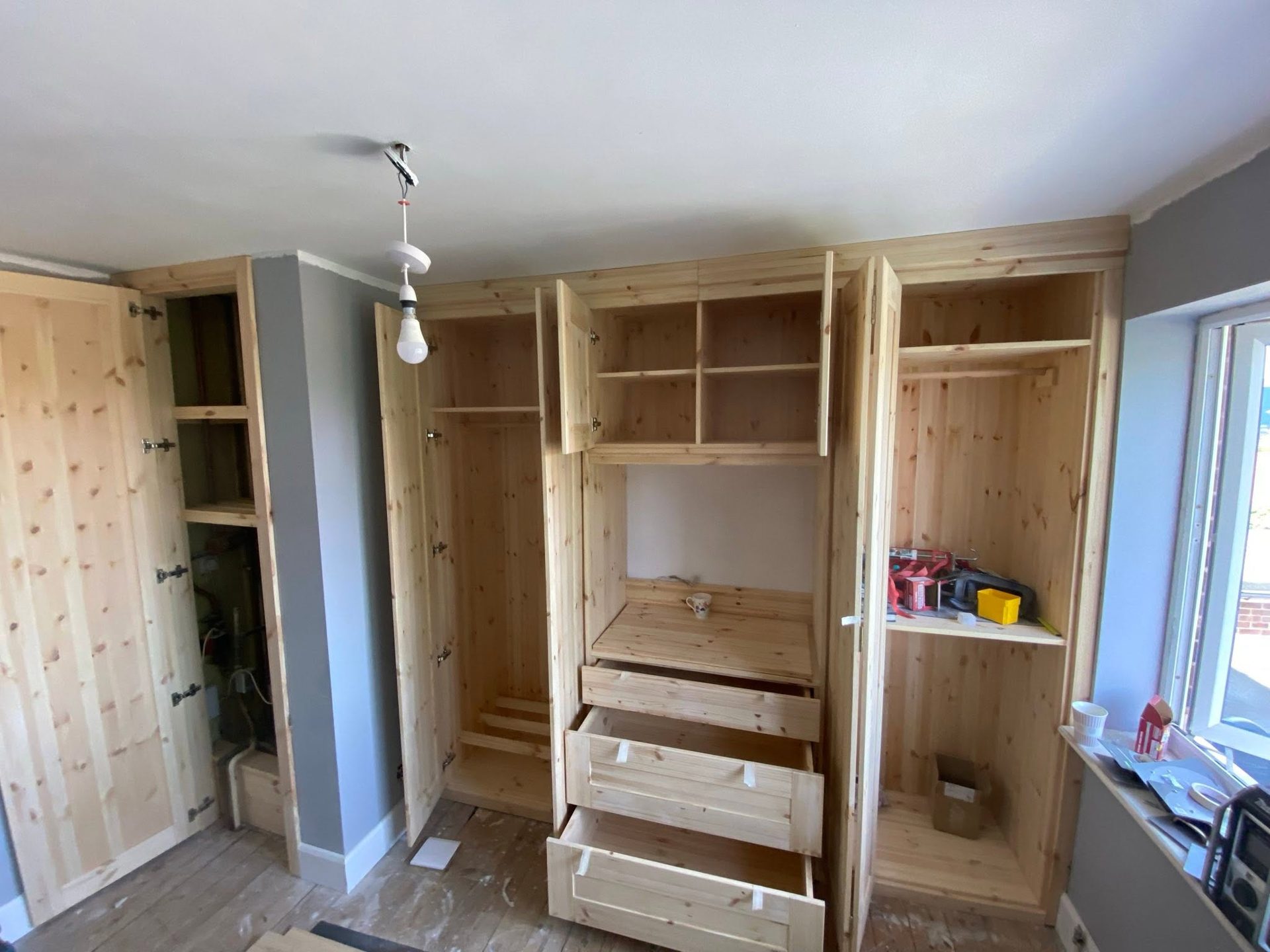 Fitted pine wardrobes during installation, shelving and hanging space by SGC carpenter