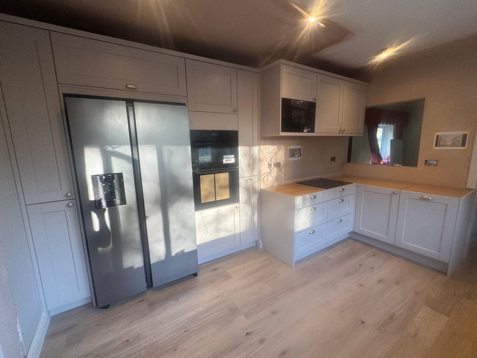 Grey shaker kitchen with integrated oven and American fridge freezer housing